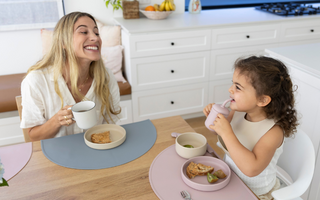 Mom and toddler eating at table with mess-free silicone placemats, easy clean food catcher for meals
