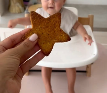 Star-shaped toast offered to baby in high chair, mess-free mealtime solution