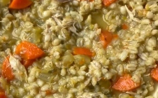 Hearty chicken barley soup with carrots and celery in a white bowl, perfect for mess-free meals.